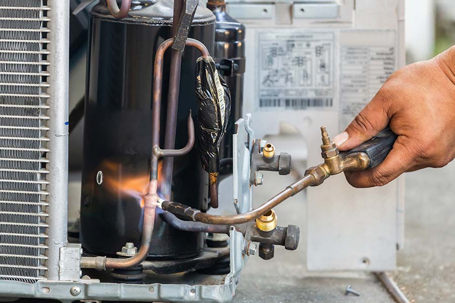 HVAC technician brazing copper lines