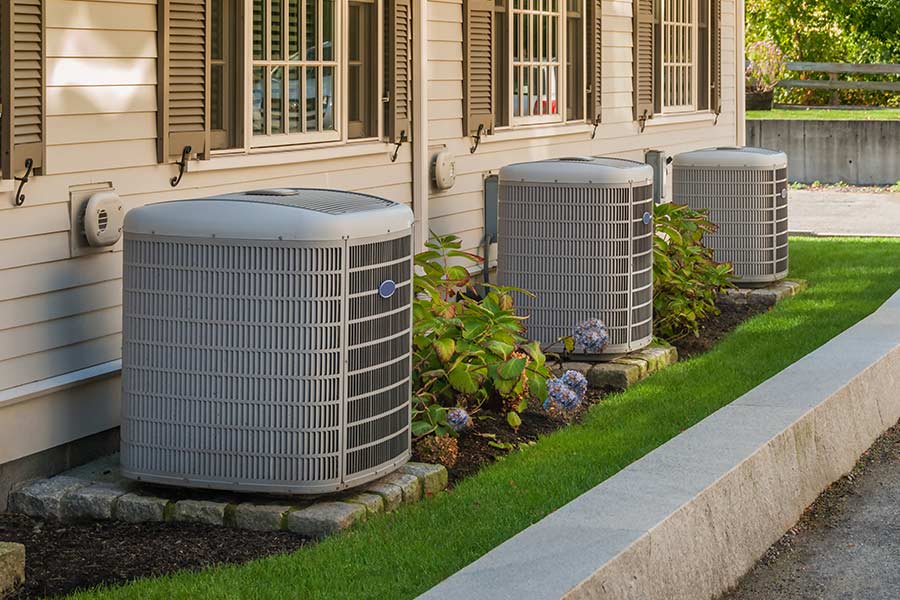 Three outdoor AC units outside residential building